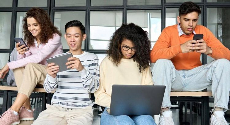 Group of students in the UAE using laptops, tablets and phones for online exam preparation